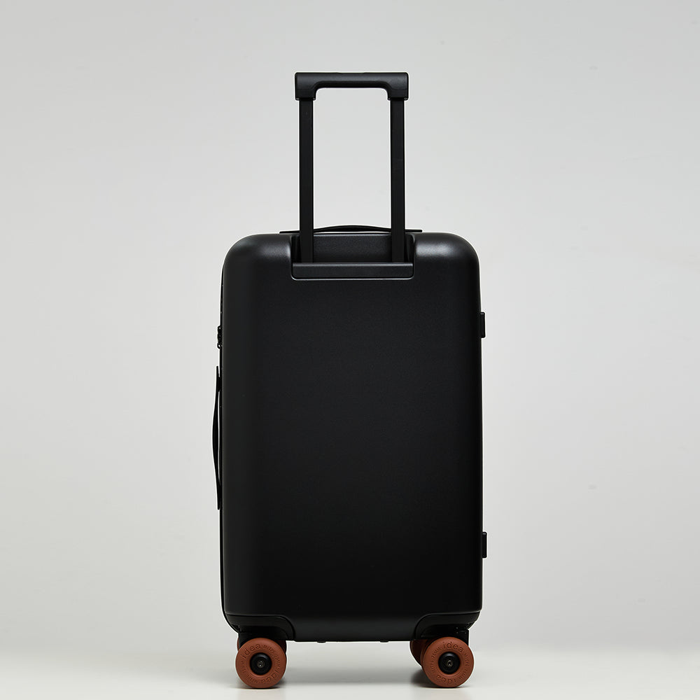 Back view of Lovetour black spinner suitcase with extended aluminum trolley handle and caramel brown wheels