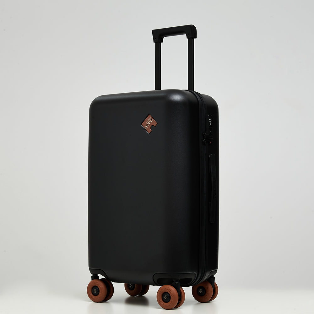 Lovetour black hardside luggage with contrast caramel brown 3-inch donut wheels, 45-degree angle view showing TSA lock and side handle