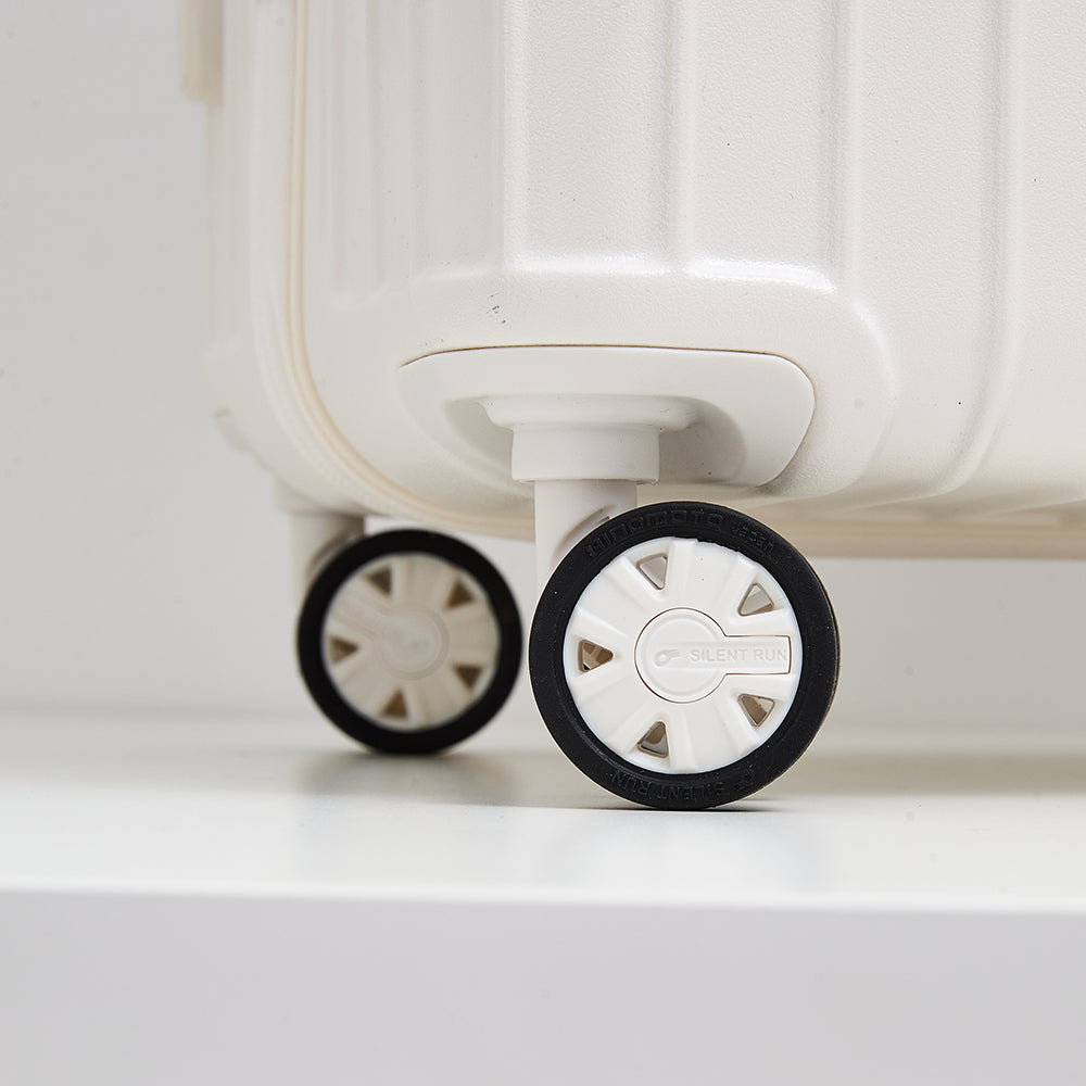 Detail view of the premium Hinomoto Silent Run double spinner wheels on the Lovetour off-white luggage