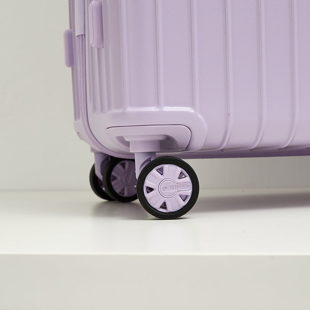 Close-up of silent run wheels on lavender suitcase